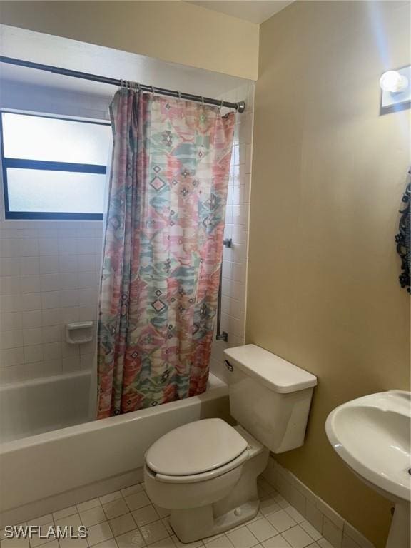 full bathroom with shower / bath combination with curtain, tile patterned floors, a sink, and toilet