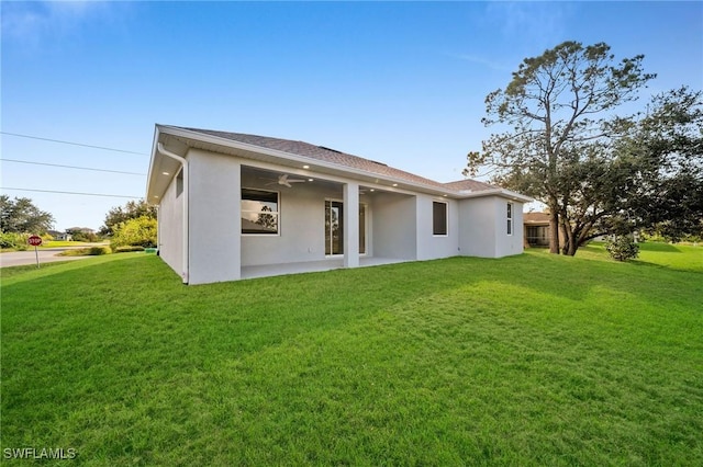 3800 11th St SW, Lee, FL 33976 - back of house with stucco siding, ceiling fan, and a lawn