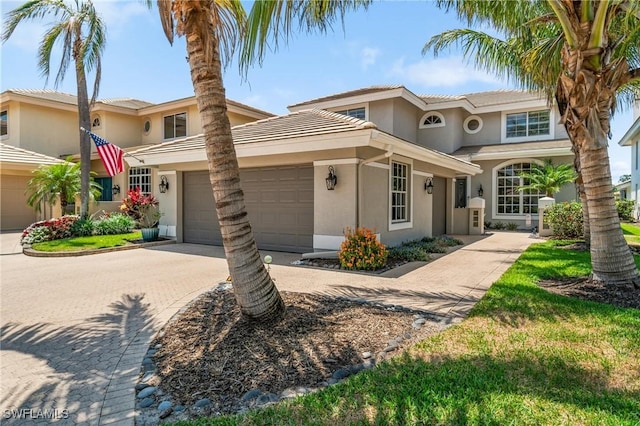 10334 Quail Crown Dr, Naples, FL 34119 - view of front of house with stucco siding, an attached garage, and driveway
