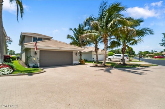 10334 Quail Crown Dr, Naples, FL 34119 - view of front of home with a garage, driveway, and stucco siding
