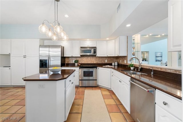 10334 Quail Crown Dr, Naples, FL 34119 - kitchen with stainless steel appliances, a sink, dark countertops, tasteful backsplash, and a kitchen island
