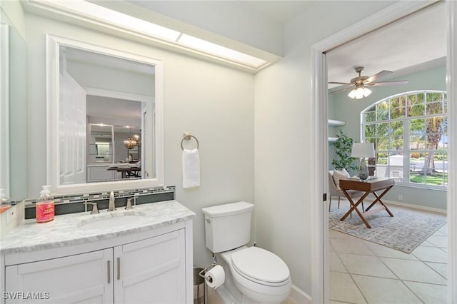 10334 Quail Crown Dr, Naples, FL 34119 - bathroom with tile patterned floors, toilet, vanity, baseboards, and ceiling fan