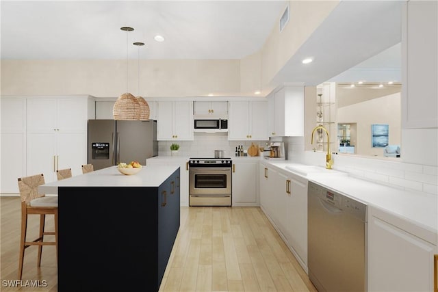 10334 Quail Crown Dr, Naples, FL 34119 - kitchen with stainless steel appliances, a sink, decorative backsplash, light countertops, and white cabinetry