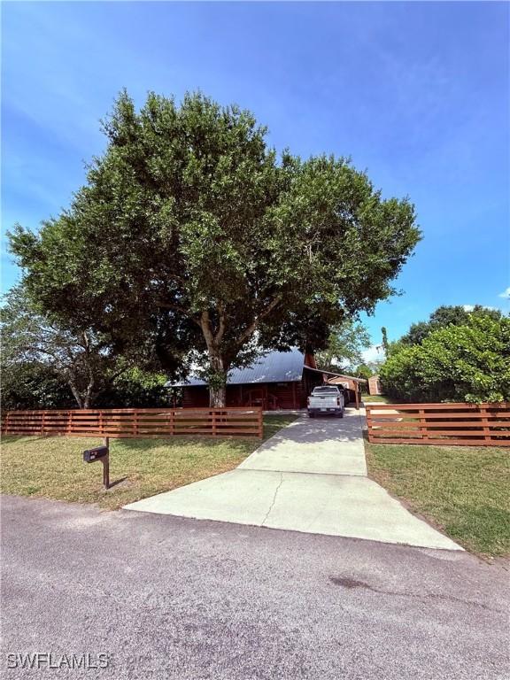 304 Flagler St, Clewiston, FL 33440 - view of front of house with driveway and a carport