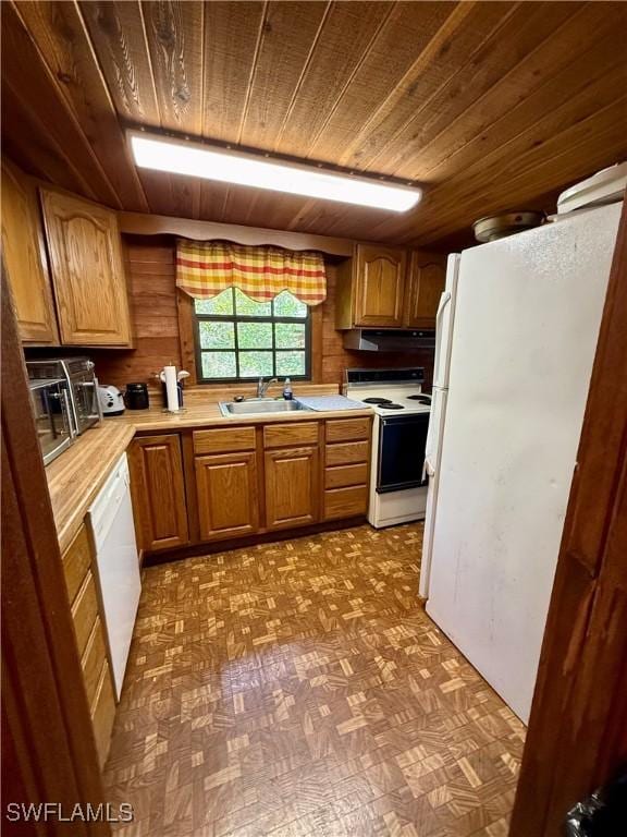 304 Flagler St, Clewiston, FL 33440 - kitchen featuring white appliances, wood ceiling, light countertops, a sink, and brown cabinets