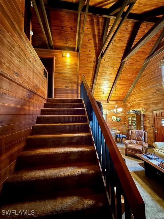 304 Flagler St, Clewiston, FL 33440 - stairway featuring wooden walls, wood ceiling, and carpet