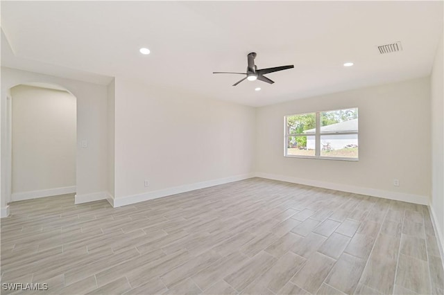 4733/4735 28th St SW, Lehigh Acres, FL 33973 - unfurnished room with a ceiling fan, arched walkways, light wood finished floors, baseboards, and recessed lighting