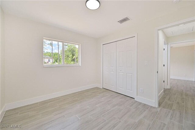 4733/4735 28th St SW, Lehigh Acres, FL 33973 - unfurnished bedroom with baseboards, light wood-style flooring, and a closet