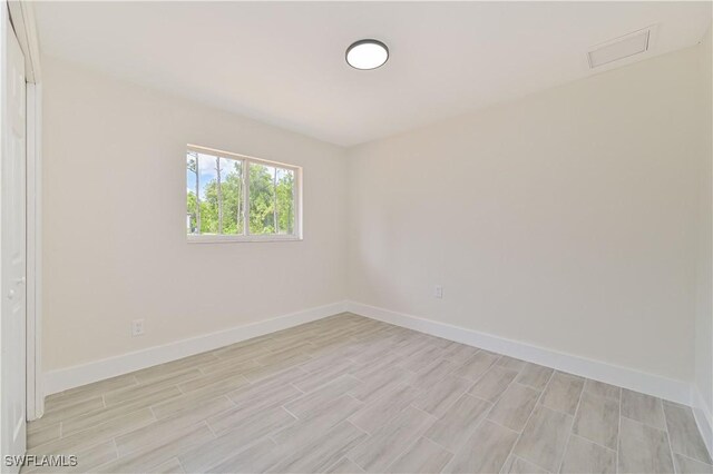 4733/4735 28th St SW, Lehigh Acres, FL 33973 - spare room featuring wood finish floors and baseboards