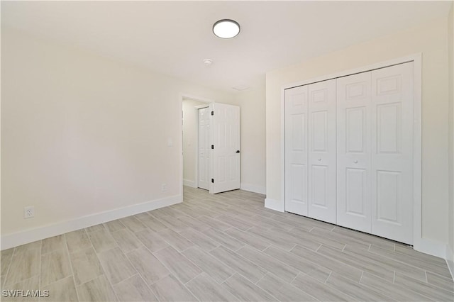 4733/4735 28th St SW, Lehigh Acres, FL 33973 - unfurnished bedroom featuring baseboards, light wood-style floors, and a closet