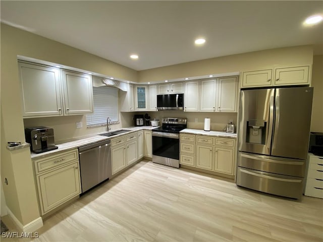 357 Joel Blvd Unit 112, Lehigh Acres, FL 33936 - kitchen with appliances with stainless steel finishes, a sink, light countertops, recessed lighting, and light wood finished floors