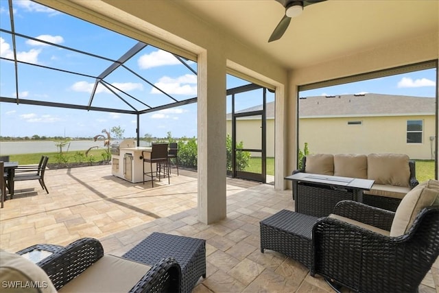 view of patio with an outdoor hangout area, glass enclosure, a ceiling fan, and a water view