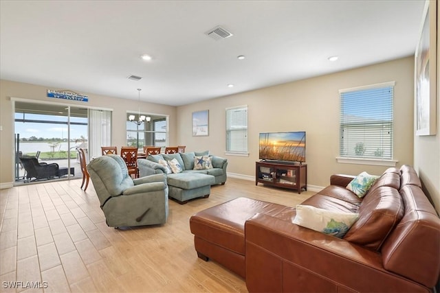 living room featuring a chandelier, light wood-type flooring, recessed lighting, and baseboards