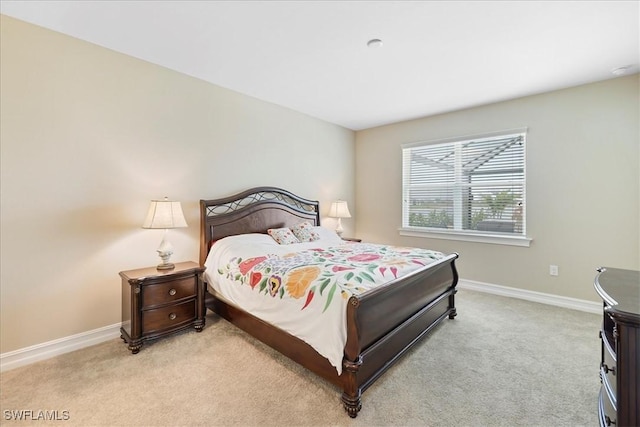 bedroom with light colored carpet and baseboards