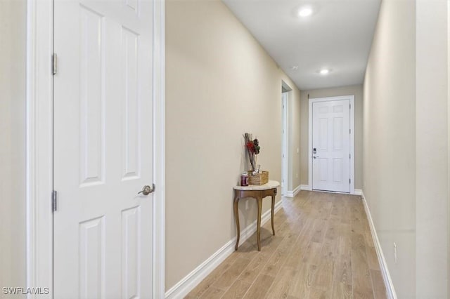 corridor with light wood finished floors, baseboards, and recessed lighting