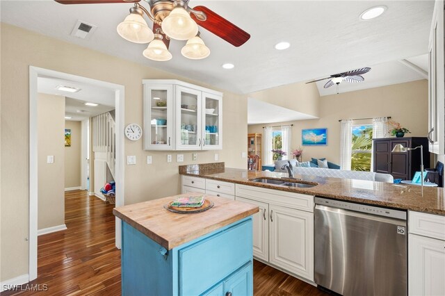 kitchen featuring dishwasher, a sink, wooden counters, ceiling fan, and white cabinetry
