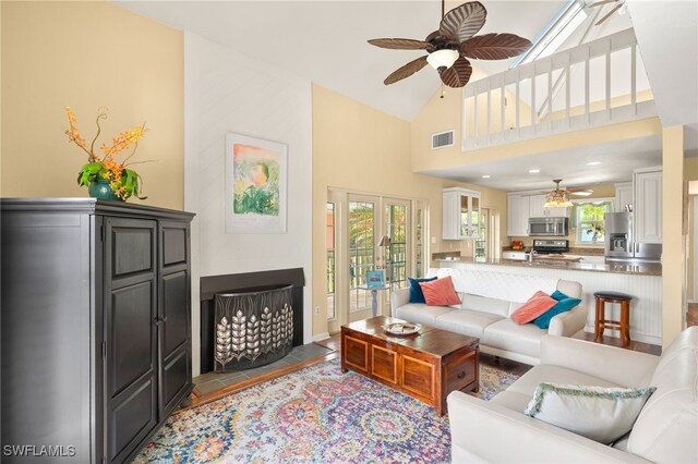 living area featuring a ceiling fan, high vaulted ceiling, and french doors