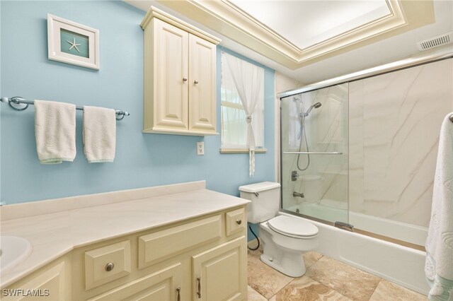 full bath featuring vanity, shower / bath combination with glass door, toilet, and tile patterned flooring