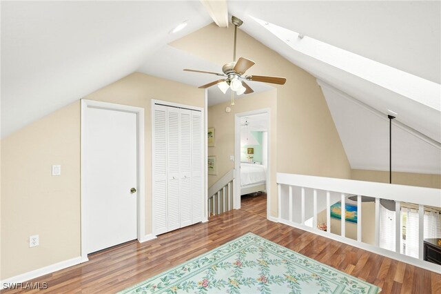 bonus room featuring lofted ceiling, wood finished floors, a ceiling fan, and a skylight