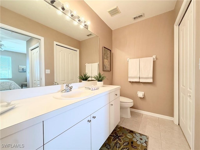 ensuite bathroom featuring vanity, toilet, tile patterned flooring, baseboards, and ceiling fan
