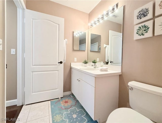 bathroom with toilet, vanity, and baseboards