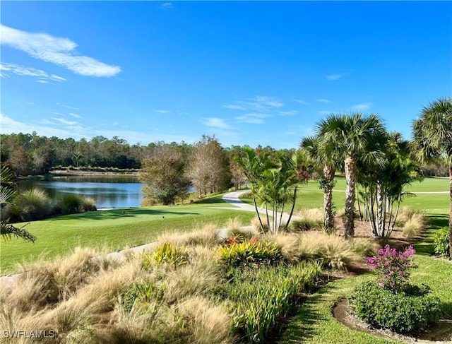 view of home's community with a water view, golf course view, and a lawn