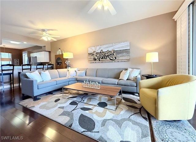 living room with a ceiling fan, dark wood-style flooring, and baseboards