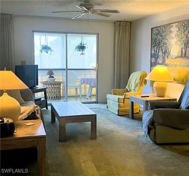living room featuring carpet, ceiling fan, and a textured ceiling