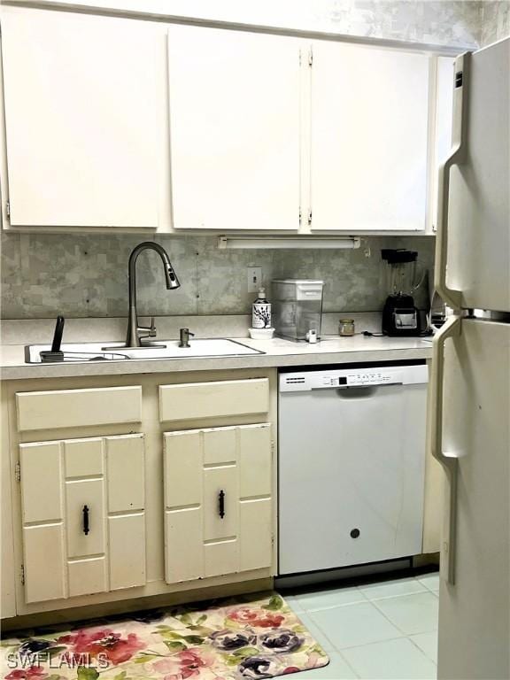 kitchen featuring white appliances, light countertops, a sink, and tile patterned flooring