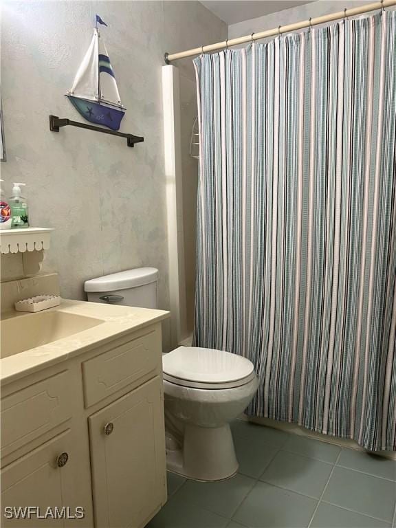bathroom featuring tile patterned flooring, toilet, vanity, and curtained shower
