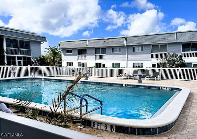 community pool with fence and a patio