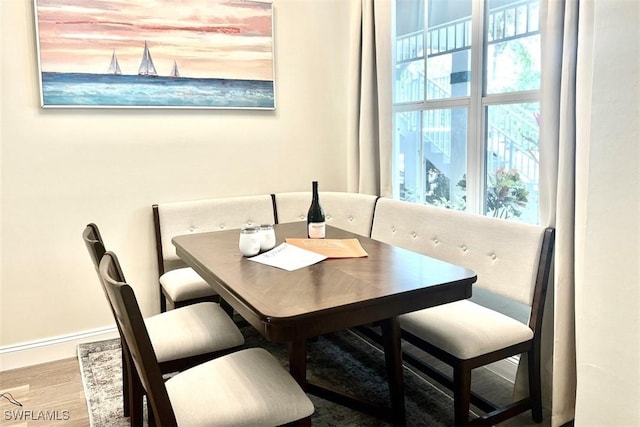dining space featuring wood finished floors and baseboards