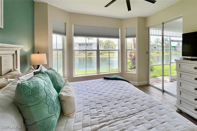 bedroom featuring access to exterior, wood finished floors, baseboards, and a ceiling fan