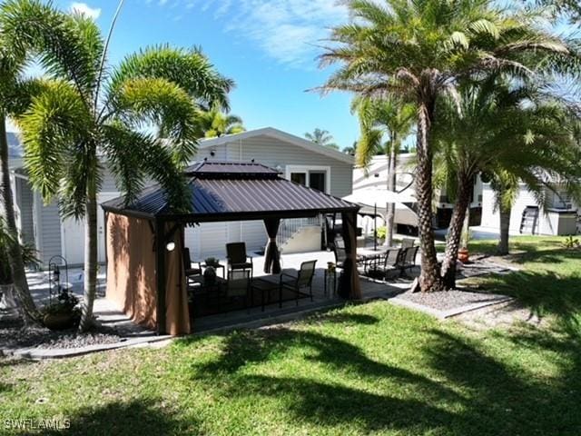5570 Cypresswoods Resort Dr, Fort Myers, FL 33905 - rear view of house featuring a gazebo, a lawn, and metal roof