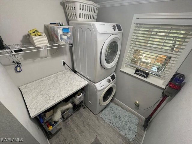 5570 Cypresswoods Resort Dr, Fort Myers, FL 33905 - clothes washing area featuring estacked washer and dryer, wood finished floors, and crown molding