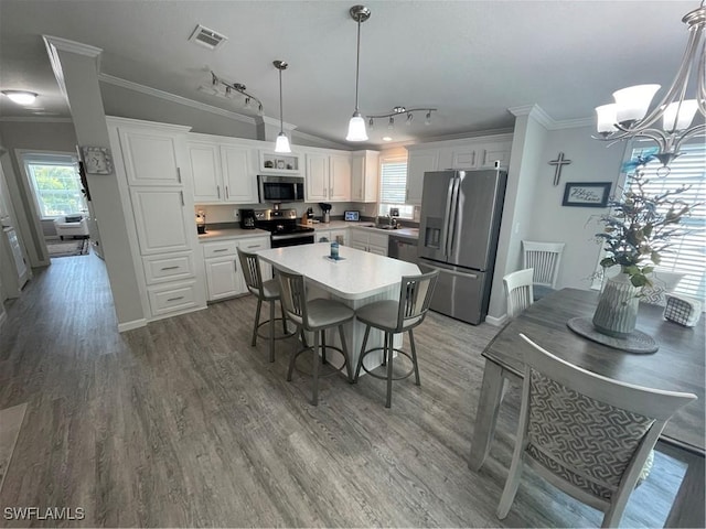 5570 Cypresswoods Resort Dr, Fort Myers, FL 33905 - kitchen featuring appliances with stainless steel finishes, ornamental molding, a sink, rail lighting, and white cabinets