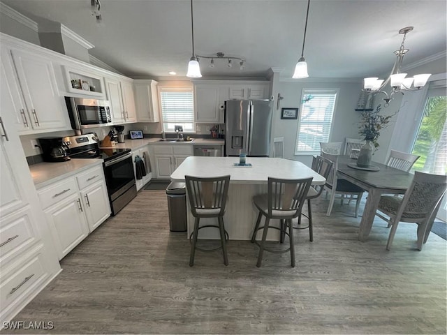5570 Cypresswoods Resort Dr, Fort Myers, FL 33905 - kitchen with stainless steel appliances, crown molding, a sink, a breakfast bar area, and white cabinets