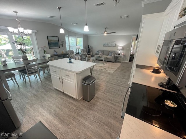 5570 Cypresswoods Resort Dr, Fort Myers, FL 33905 - kitchen featuring white cabinetry, vaulted ceiling, light countertops, light wood-type flooring, and open floor plan