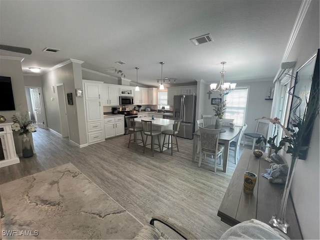 5570 Cypresswoods Resort Dr, Fort Myers, FL 33905 - living room featuring crown molding, light wood-style floors, baseboards, and a chandelier