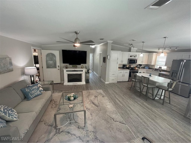 5570 Cypresswoods Resort Dr, Fort Myers, FL 33905 - living area featuring light wood-style flooring, ornamental molding, a fireplace, a ceiling fan, and baseboards