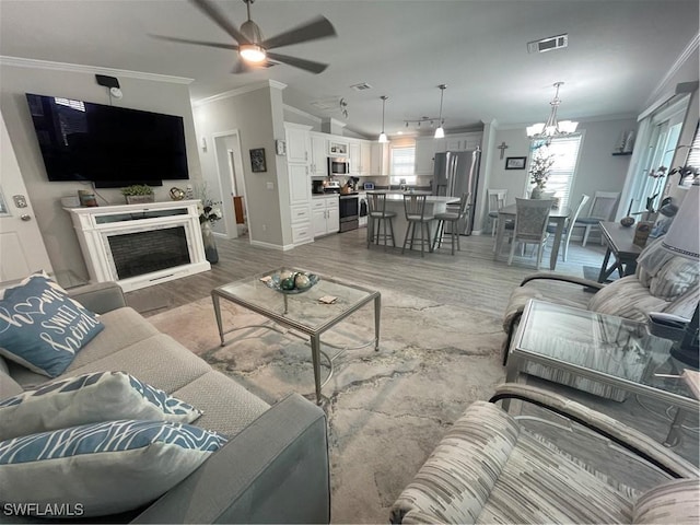 5570 Cypresswoods Resort Dr, Fort Myers, FL 33905 - living room with crown molding, light wood-style floors, a ceiling fan, a chandelier, and baseboards