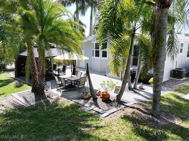 5570 Cypresswoods Resort Dr, Fort Myers, FL 33905 - view of green lawn featuring central air condition unit and a patio