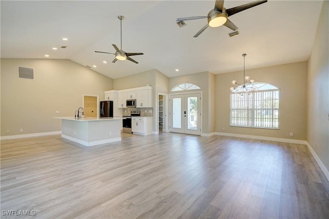 unfurnished living room featuring ceiling fan, a sink, light wood-style flooring, baseboards, and recessed lighting