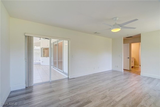 empty room with light wood-style floors, a ceiling fan, and baseboards