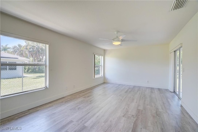 empty room featuring light wood-style flooring, a ceiling fan, and baseboards