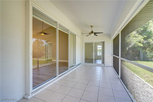 unfurnished sunroom featuring ceiling fan and vaulted ceiling