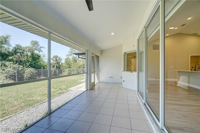 unfurnished sunroom featuring vaulted ceiling