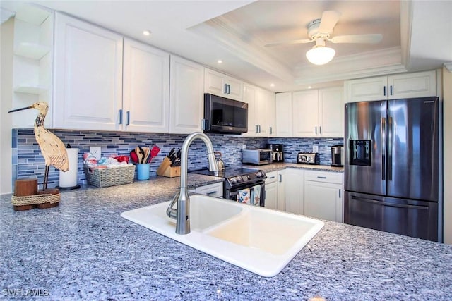 kitchen with stainless steel refrigerator with ice dispenser, a raised ceiling, white cabinetry, a sink, and backsplash