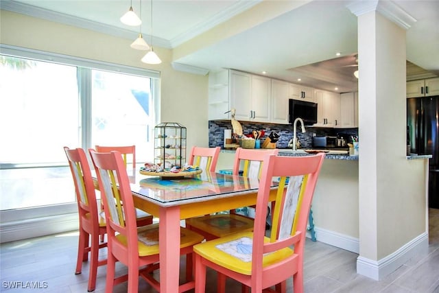dining area featuring crown molding, baseboards, light wood-style floors, and recessed lighting