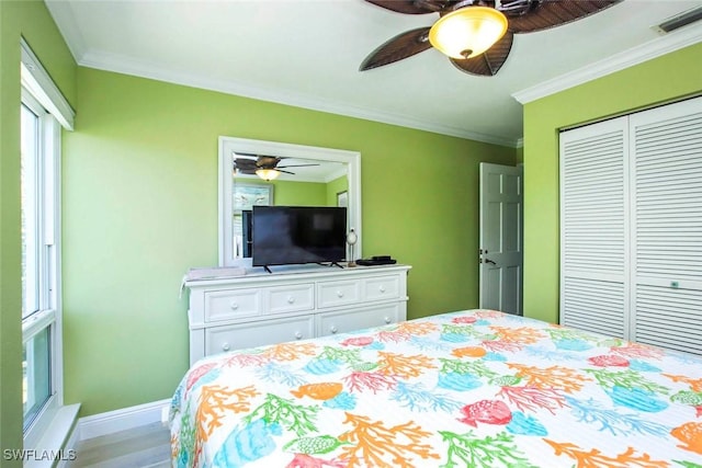 bedroom with baseboards, a closet, ornamental molding, wood finished floors, and a ceiling fan